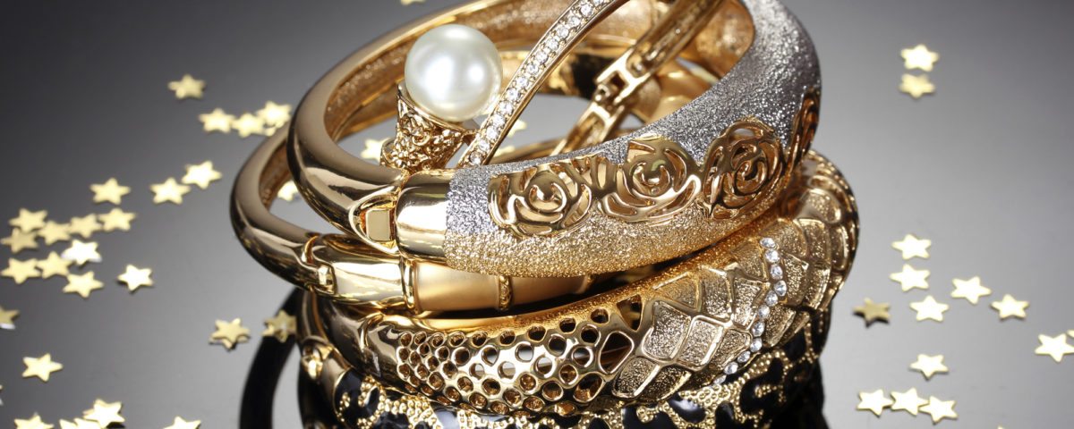 Beautiful golden bracelets on grey background